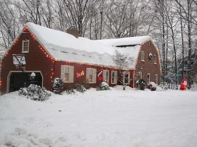 view of front facade with a chimney and a gambrel roof