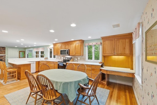 dining room featuring light wood finished floors, wallpapered walls, recessed lighting, and baseboards