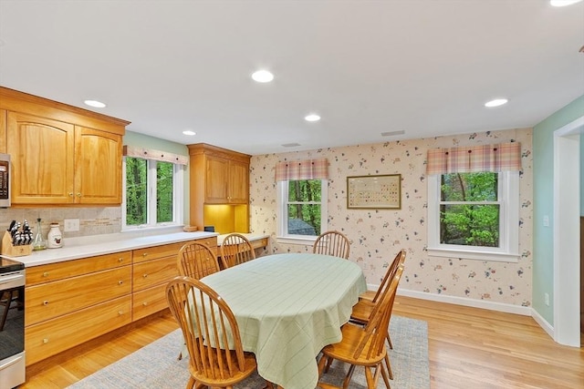 dining area with light wood finished floors, baseboards, wallpapered walls, and recessed lighting