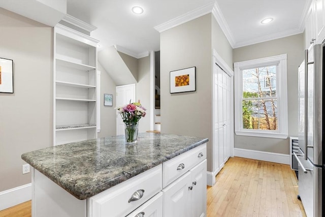 kitchen with freestanding refrigerator, ornamental molding, baseboards, white cabinetry, and light wood-style flooring