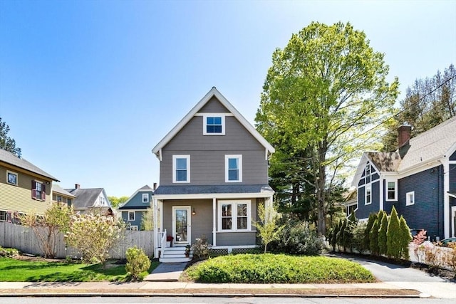 traditional style home featuring a porch and fence