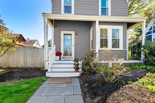 entrance to property with fence and covered porch