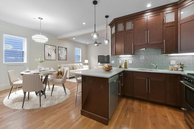 870 E 4th St Unit 1, Boston, MA 02127 - kitchen featuring stainless steel appliances, a peninsula, light wood finished floors, tasteful backsplash, and ornamental molding