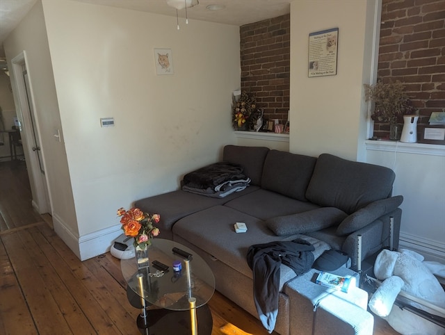 living room featuring brick wall and hardwood / wood-style floors