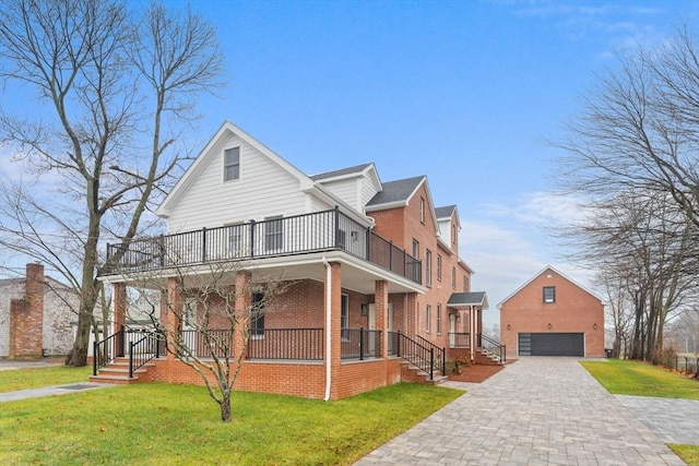 view of front of home with a garage, covered porch, a front lawn, and a balcony