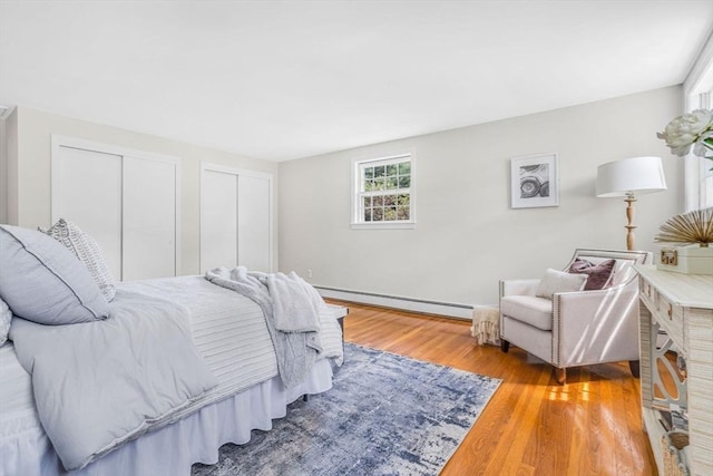 4 Fairway Rd, Acton, MA 01720 - bedroom with a baseboard radiator, wood finished floors, and two closets