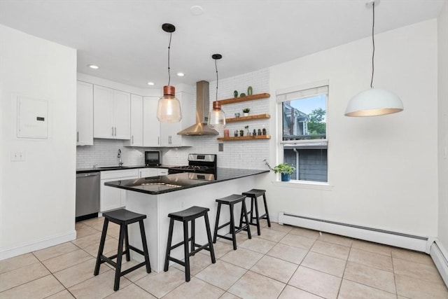 112 Thornton St Unit 2, Boston, MA 02119 - kitchen featuring wall chimney exhaust hood, stainless steel appliances, dark countertops, white cabinets, and a kitchen breakfast bar