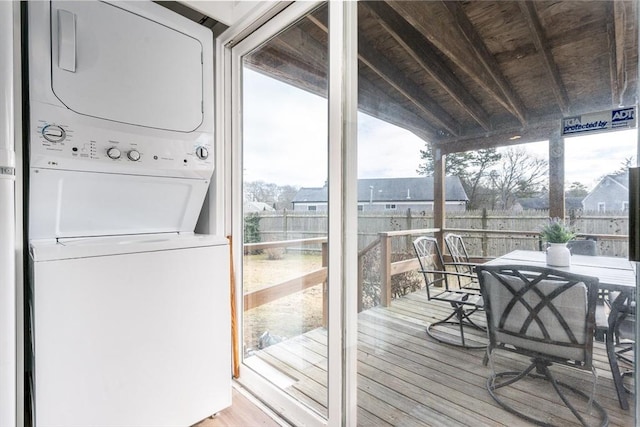 wooden terrace with stacked washer / drying machine