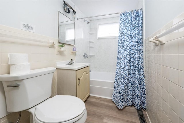 full bathroom with toilet, tile walls, vanity, shower / bath combo, and hardwood / wood-style floors