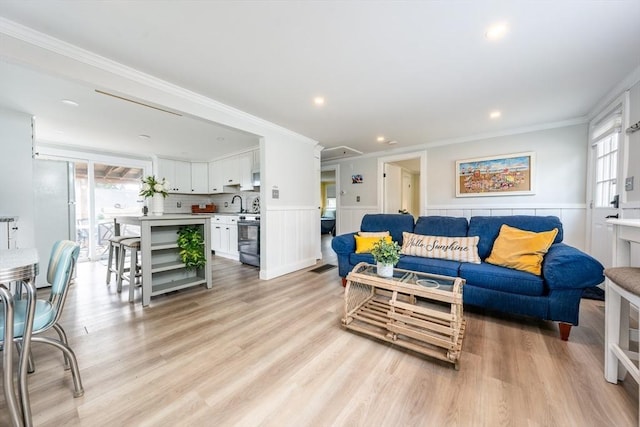 living room featuring ornamental molding, a wealth of natural light, and light wood-type flooring