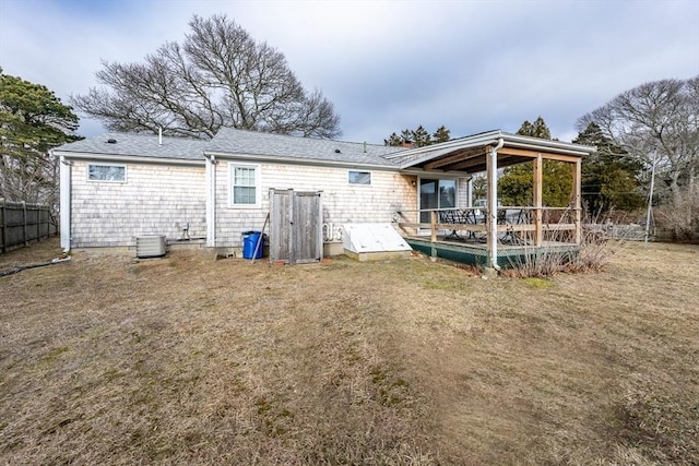 back of property with a yard and central AC