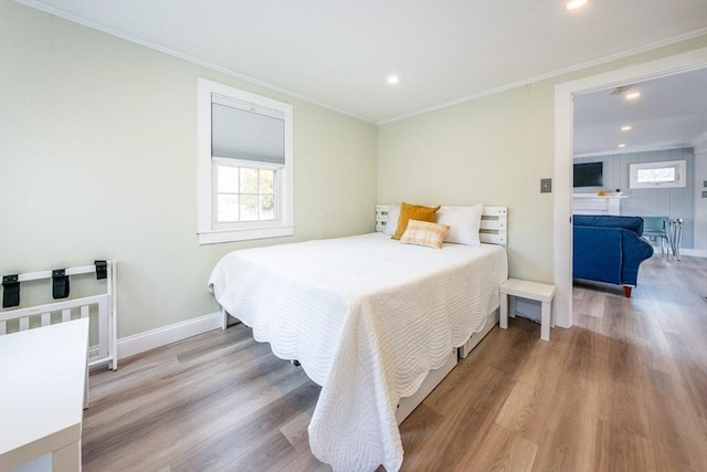 bedroom featuring crown molding and light wood-type flooring