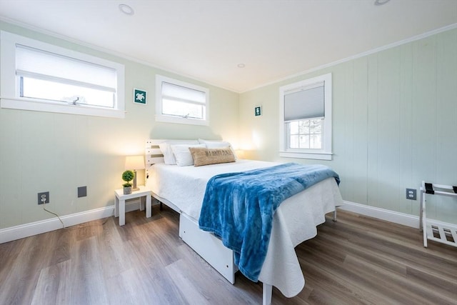 bedroom with hardwood / wood-style flooring, crown molding, and multiple windows