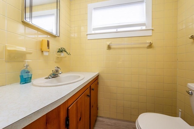 bathroom featuring vanity, toilet, wood-type flooring, and a wealth of natural light