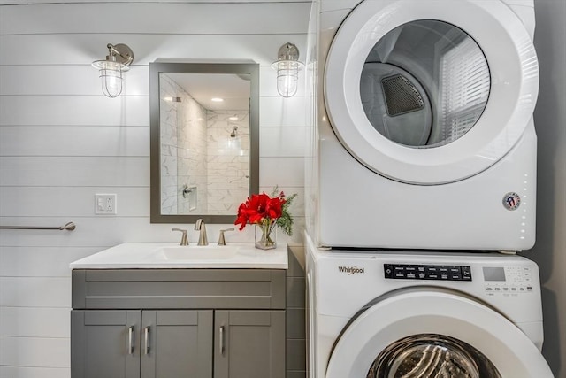 laundry room featuring stacked washer / drying machine and sink