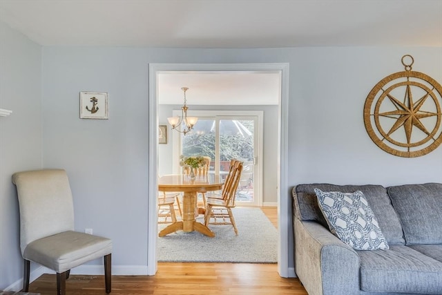 dining area with hardwood / wood-style flooring and an inviting chandelier