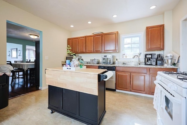 93 Bank St, North Attleboro, MA 02760 - kitchen with stainless steel dishwasher, a sink, white gas range oven, brown cabinets, and a center island
