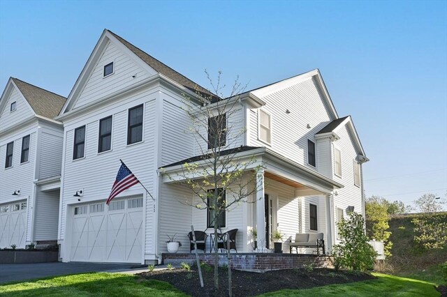 11 Bailey Pond Ln Unit 11, Amesbury, MA 01913 - view of front facade with covered porch, a garage, a front yard, and driveway
