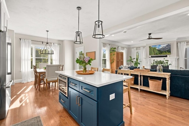 11 Bailey Pond Ln Unit 11, Amesbury, MA 01913 - kitchen featuring freestanding refrigerator, blue cabinets, a breakfast bar area, a ceiling fan, and a kitchen island