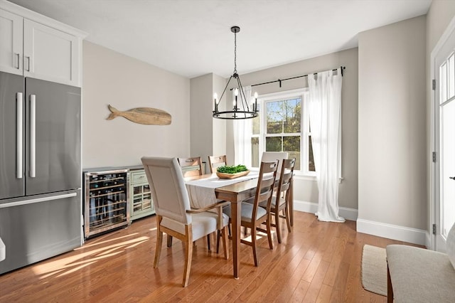 11 Bailey Pond Ln Unit 11, Amesbury, MA 01913 - dining room featuring wine cooler, a chandelier, baseboards, and light wood-style flooring
