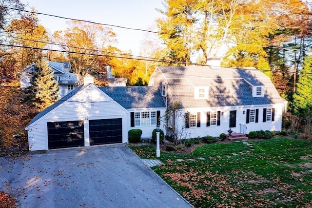 cape cod house featuring a garage and a front yard