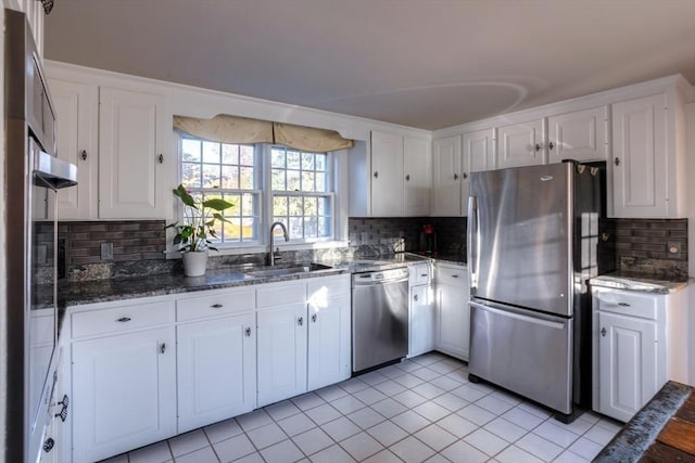 kitchen featuring light tile patterned flooring, sink, tasteful backsplash, appliances with stainless steel finishes, and white cabinets