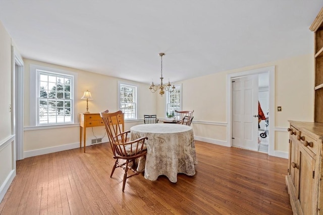 dining room featuring an inviting chandelier and light wood-type flooring