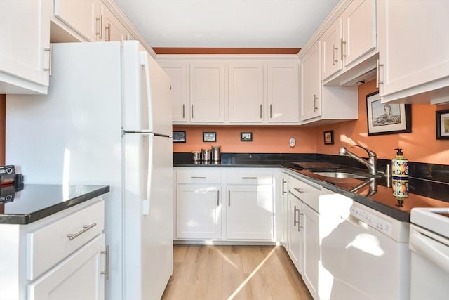 14 Harold St Unit D, Harwich, MA 02646 - kitchen featuring white appliances, white cabinetry, light wood finished floors, and dark countertops