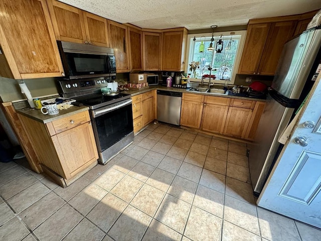 45 River St, Belchertown, MA 01007 - kitchen with appliances with stainless steel finishes, light tile patterned floors, brown cabinetry, and a textured ceiling