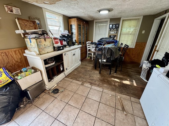 45 River St, Belchertown, MA 01007 - kitchen featuring a wainscoted wall, wooden walls, light tile patterned floors, light countertops, and a textured ceiling