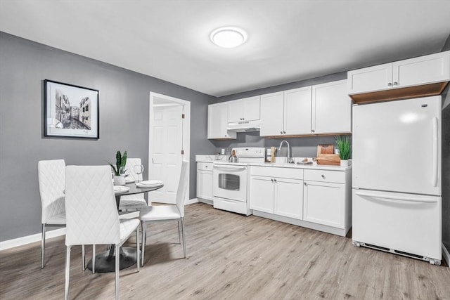 kitchen featuring light wood finished floors, light countertops, white appliances, and white cabinets