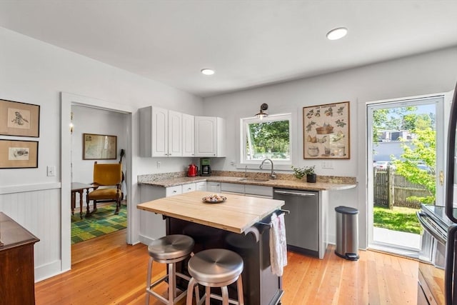 250 Arlington St Unit A, Acton, MA 01720 - kitchen featuring stainless steel dishwasher, butcher block counters, a sink, light wood finished floors, and recessed lighting