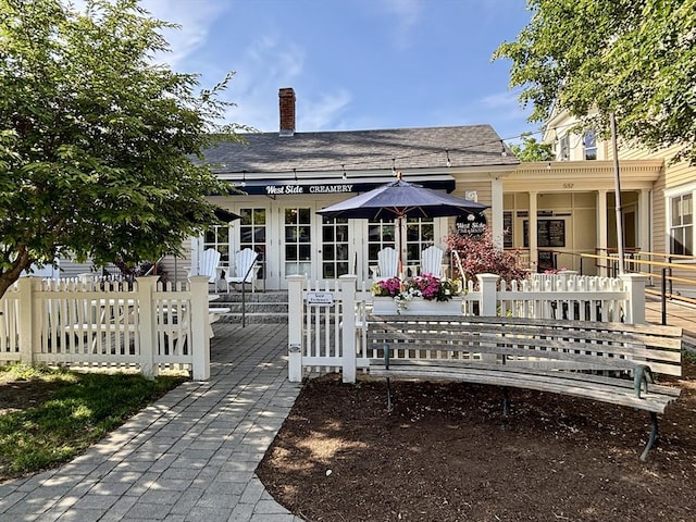 250 Arlington St Unit A, Acton, MA 01720 - rear view of house featuring a fenced front yard, a chimney, and a shingled roof