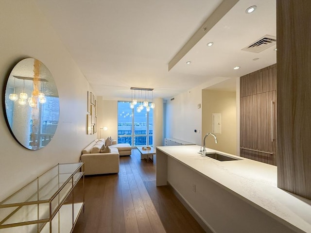 bathroom with hardwood / wood-style floors, a notable chandelier, and sink