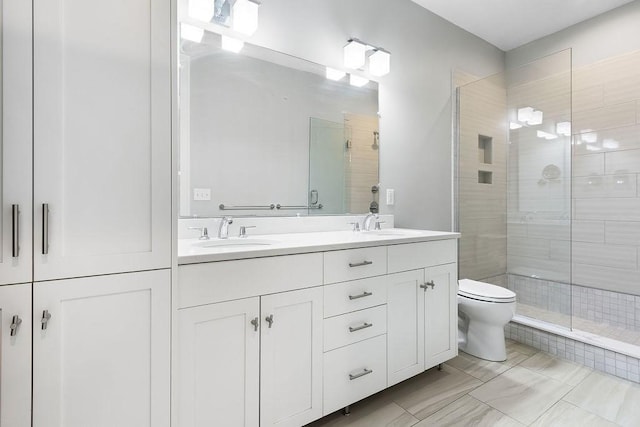 full bath with a stall shower, toilet, and double vanity