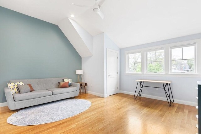 living room with lofted ceiling, wood finished floors, a ceiling fan, and baseboards