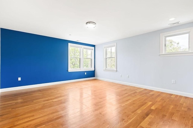 spare room featuring light wood finished floors and baseboards