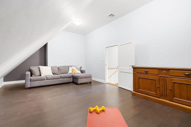living room with lofted ceiling, dark wood-style flooring, and baseboards