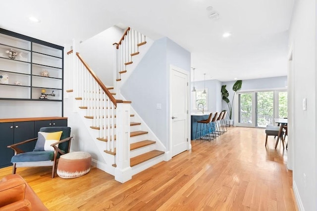 stairway featuring wood finished floors, baseboards, and recessed lighting