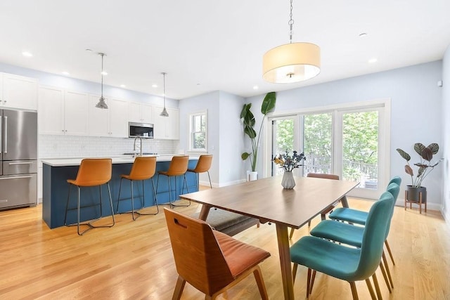 dining room featuring light wood-type flooring, recessed lighting, and baseboards