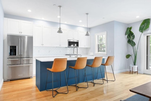 kitchen featuring stainless steel appliances, light countertops, plenty of natural light, decorative backsplash, and recessed lighting