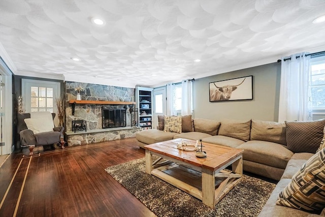 living room featuring hardwood / wood-style floors, a fireplace, and crown molding