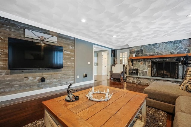 living room featuring crown molding, hardwood / wood-style flooring, and a fireplace