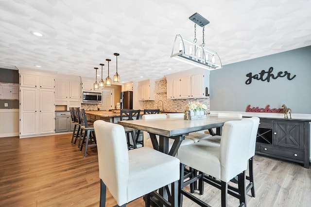 dining area with sink and light hardwood / wood-style flooring