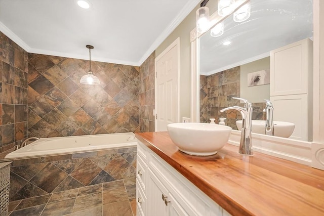 bathroom with crown molding, tiled tub, and vanity