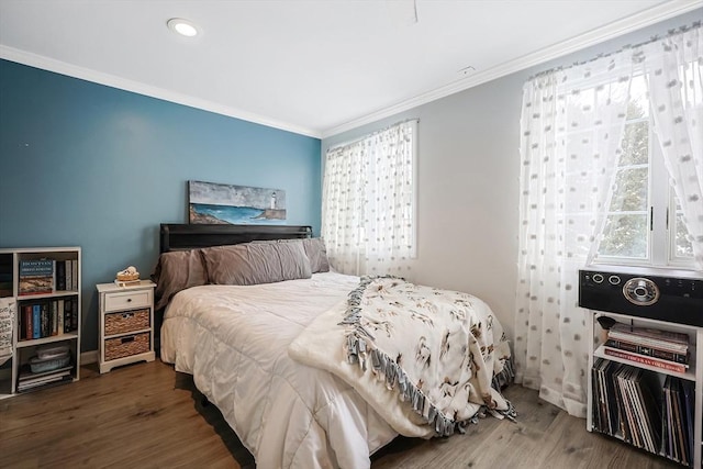 bedroom with dark hardwood / wood-style floors and ornamental molding