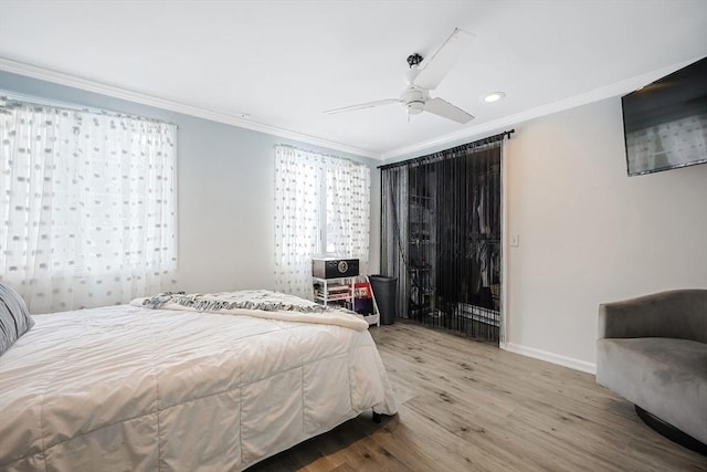 bedroom with crown molding, hardwood / wood-style floors, and ceiling fan