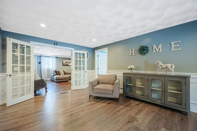 living area with hardwood / wood-style floors and french doors