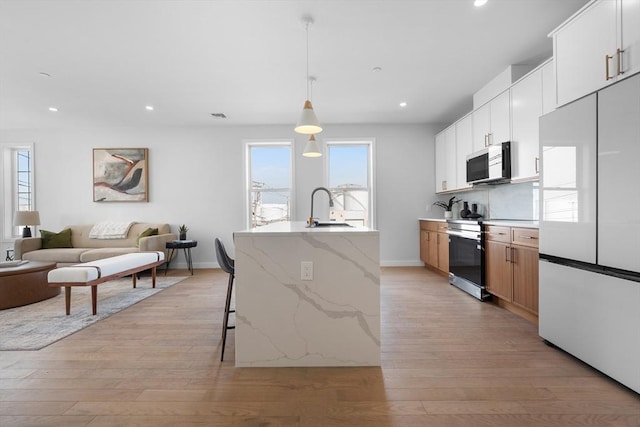 437-439 Chelsea St Unit 3R, Boston, MA 02128 - kitchen with appliances with stainless steel finishes, light wood-style floors, recessed lighting, a kitchen breakfast bar, and open floor plan