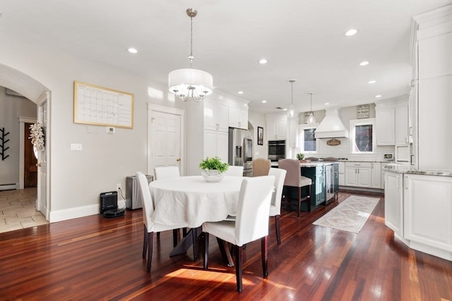 dining room featuring a baseboard radiator, dark wood-type flooring, and an inviting chandelier